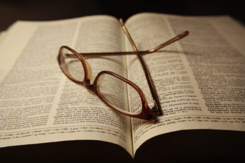 reading-glasses-atop-pages-of-open-dictionary-book-600x400.jpg